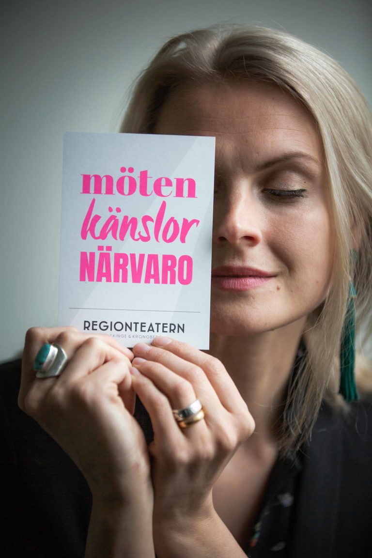 Regionteatern. VD-Therese Willstedt håller i ett vykort med Regionteatern grafiska-design.