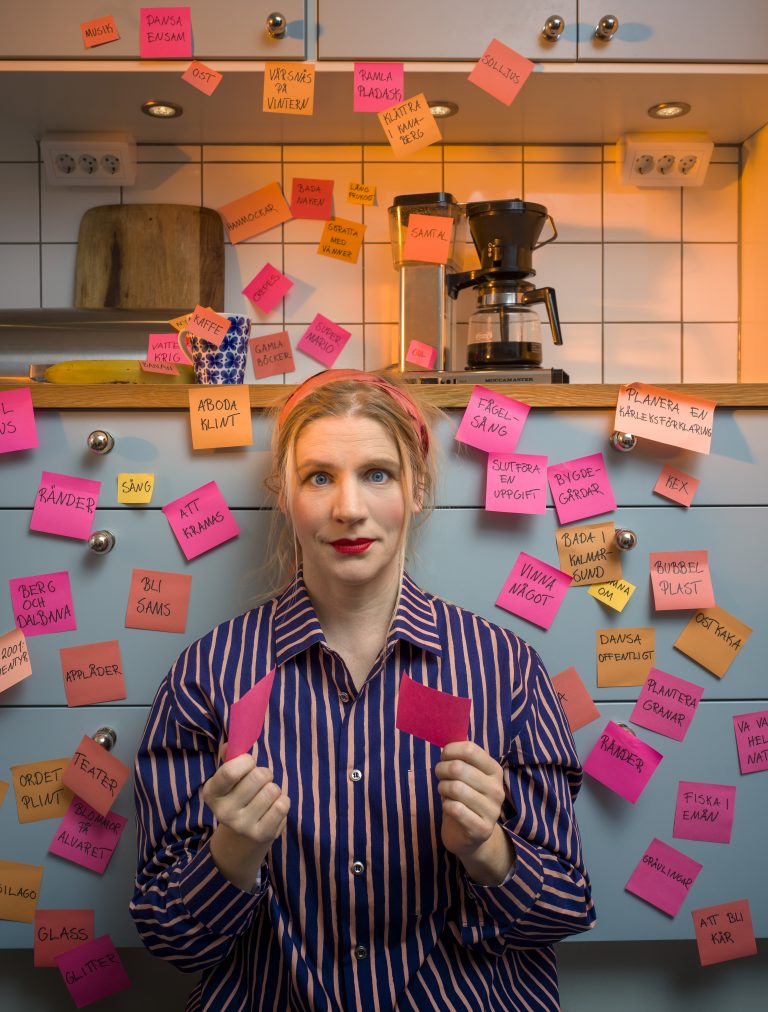 Kvinna omringad av post-it-lappar med olika ord på.