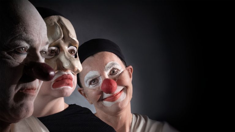 Tre personer med clownsmink. En ser in i kameran och ler.